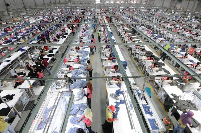 A garment factory floor with workers sewing apparel.